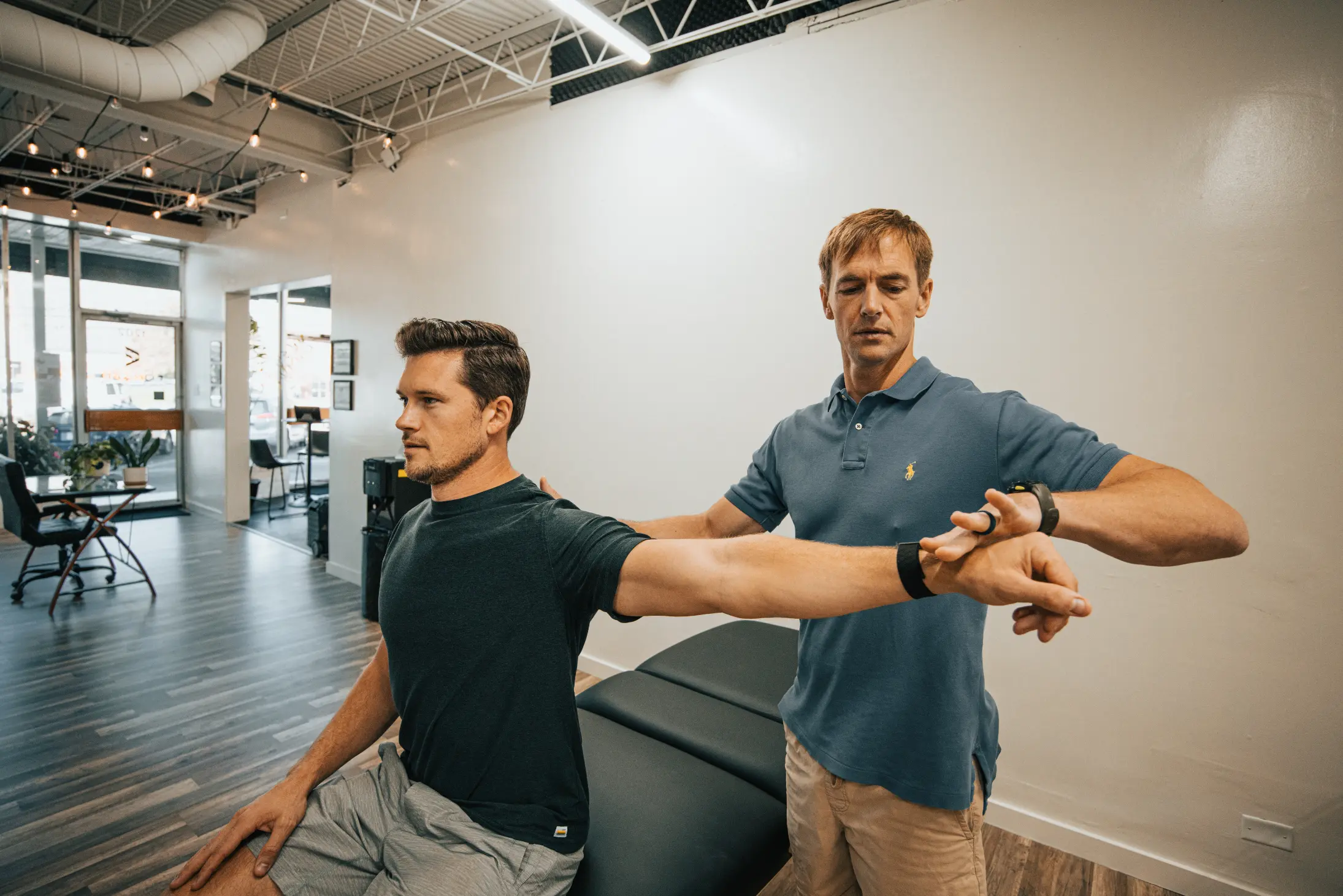 Josh Wiley providing gentle manual therapy to a client’s arm to release tension and restore movement.